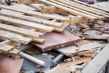 Wood recycling dump stacked on a big garbage bin on a public waste collector. Wood factory waste.