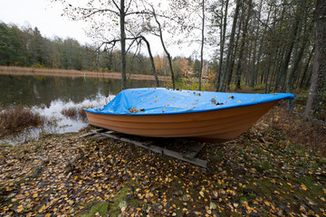 old boat in october with lots of leafs