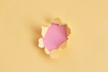 Damaged yellow paper with pink background, space for text