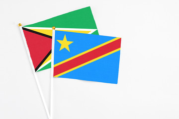 Congo and Guyana stick flags on white background. High quality fabric, miniature national flag. Peaceful global concept.White floor for copy space.