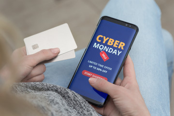 girl with a mobile phone in her hands makes purchases online on Cyber Monday