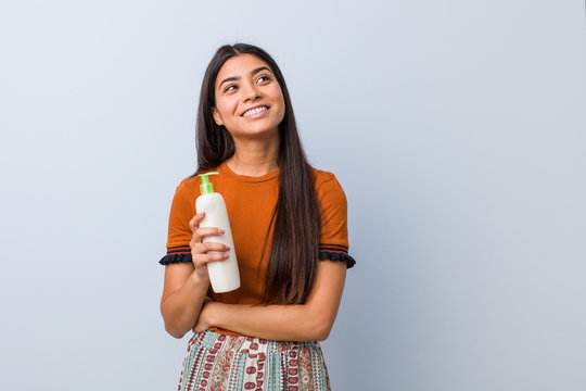 Young Arab Woman Holding A Cream Bottle Smiling Confident With Crossed Arms.