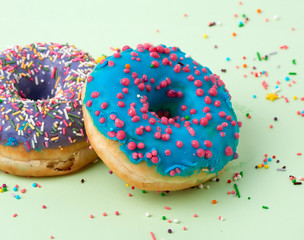 round baked donut with colored sugar sprinkles and with blue sugar icing