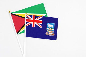 Falkland Islands and Guyana stick flags on white background. High quality fabric, miniature...