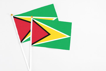 Guyana and Guyana stick flags on white background. High quality fabric, miniature national flag. Peaceful global concept.White floor for copy space.