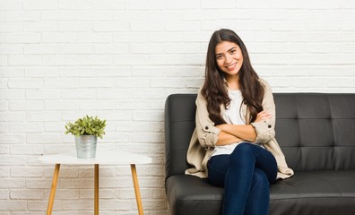 Young arab woman sitting on the sofa laughing and having fun.