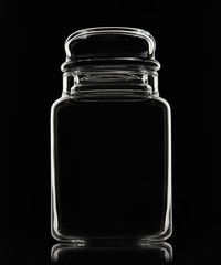 White silhouette of empty glass jar on a black background