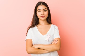 Fototapeta premium Young arab woman with a pink bow. Concept of fight against cancer.