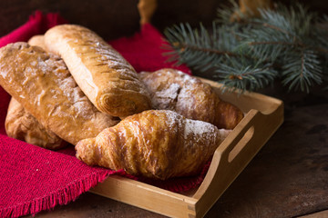 Christmas and New Year background with continental breakfast - with cinnamon orange and croissant. Decorations - snowflake , pine cones.