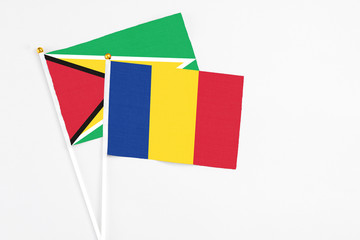 Romania and Guyana stick flags on white background. High quality fabric, miniature national flag....