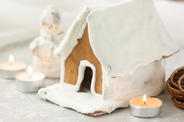 Gingerbread house. Christmas holiday sweets. European Christmas holiday traditions. Christmas gingerbread house and holiday decorations on old wooden table