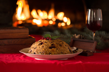 english christmas pudding with spoon. english christmas pudding with spoon. Traditional English steamed pudding with dried fruits and nuts for Christmas on the background of the fireplace