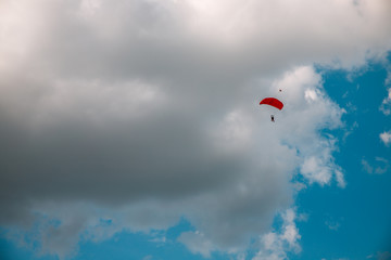 Paratrooper parachuting in blue sky. Military service