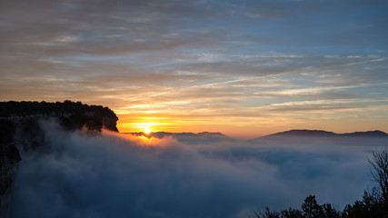 Sunrise with blue sky above the clouds in the mountains. View from high point. Very early morning...