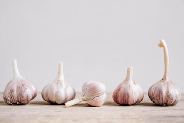 Garlic lie in a row on a rustic wooden background. Copy, empty space for text