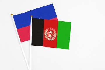 Afghanistan and Haiti stick flags on white background. High quality fabric, miniature national...