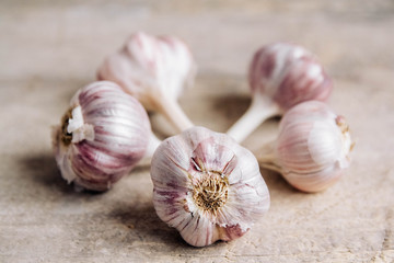 Garlics lie on a rustic wooden background. Copy, empty space for text