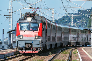 Naklejka premium Passenger double deck train moves along the platform by Black Sea.