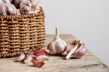 Garlic in a wicker basket on a wooden table background. Copy, empty space for text