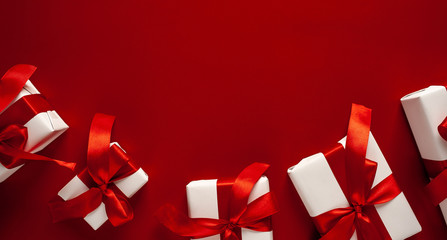 Christmas composition on a white background with white gift boxes, with a red ribbon with fir...