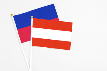 Austria and Haiti stick flags on white background. High quality fabric, miniature national flag. Peaceful global concept.White floor for copy space.