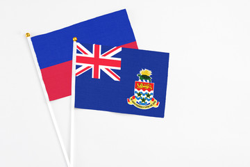 Cayman Islands and Haiti stick flags on white background. High quality fabric, miniature national...