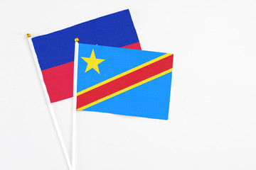 Congo and Haiti stick flags on white background. High quality fabric, miniature national flag. Peaceful global concept.White floor for copy space.