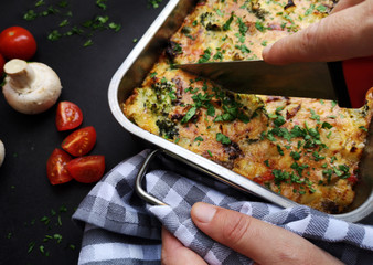 Hand cuting frittata with vegetables
