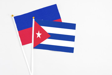 Cuba and Haiti stick flags on white background. High quality fabric, miniature national flag. Peaceful global concept.White floor for copy space.