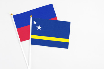 Curacao and Haiti stick flags on white background. High quality fabric, miniature national flag. Peaceful global concept.White floor for copy space.