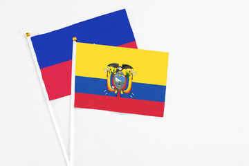 Ecuador and Haiti stick flags on white background. High quality fabric, miniature national flag. Peaceful global concept.White floor for copy space.