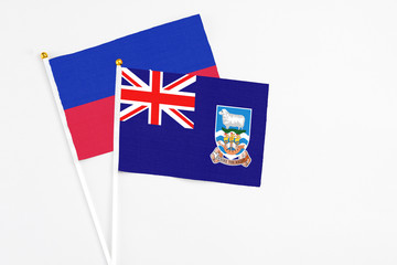 Falkland Islands and Haiti stick flags on white background. High quality fabric, miniature national...