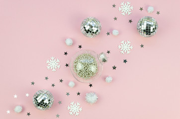 Christmas decorations on pink background. Mirror and silver glass Christmas tree balls diagonal chain line. Composition with stars and snowflakes. Winter time and New Year card concept.