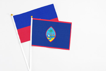 Guam and Haiti stick flags on white background. High quality fabric, miniature national flag....