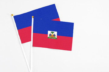 Haiti and Haiti stick flags on white background. High quality fabric, miniature national flag. Peaceful global concept.White floor for copy space.