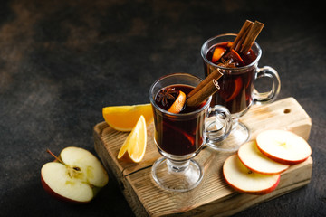 Mulled wine in glass glasses with apples, orange, cinnamon and star anise. Hot Christmas drink on a...