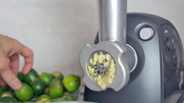 feijoa berries are crushed into jam in a meat grinder