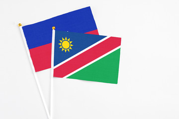 Namibia and Haiti stick flags on white background. High quality fabric, miniature national flag. Peaceful global concept.White floor for copy space.