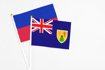 Turks And Caicos Islands and Haiti stick flags on white background. High quality fabric, miniature...