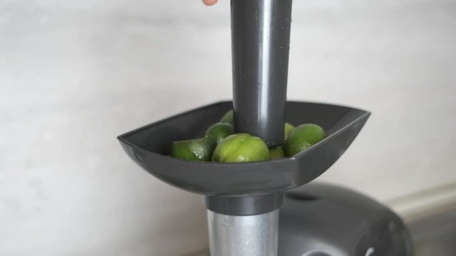 feijoa berries are pushed into a meat grinder