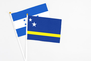Curacao and Honduras stick flags on white background. High quality fabric, miniature national flag. Peaceful global concept.White floor for copy space.