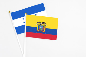 Ecuador and Honduras stick flags on white background. High quality fabric, miniature national flag. Peaceful global concept.White floor for copy space.