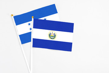 El Salvador and Honduras stick flags on white background. High quality fabric, miniature national flag. Peaceful global concept.White floor for copy space.