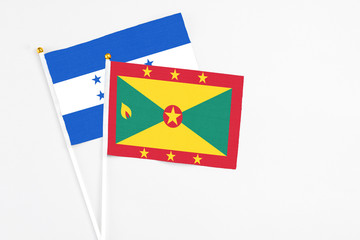 Grenada and Honduras stick flags on white background. High quality fabric, miniature national flag....
