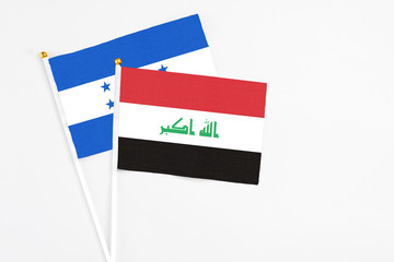 Iraq and Honduras stick flags on white background. High quality fabric, miniature national flag. Peaceful global concept.White floor for copy space.