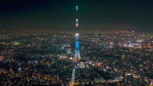 Aerial night hyper lapse time lapse Tokyo Skytree tower with Tokyo cityscape in background.Tokyo Skytree is a broadcasting, restaurant and observation tower landmark in Japan