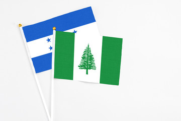 Norfolk Island and Honduras stick flags on white background. High quality fabric, miniature national flag. Peaceful global concept.White floor for copy space.