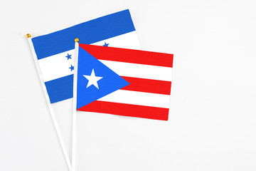 Puerto Rico and Honduras stick flags on white background. High quality fabric, miniature national flag. Peaceful global concept.White floor for copy space.