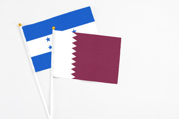 Qatar and Honduras stick flags on white background. High quality fabric, miniature national flag....