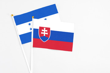 Slovakia and Honduras stick flags on white background. High quality fabric, miniature national...